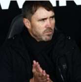 Entraîneur de football assis pendant un match