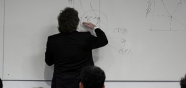 Personne écrivant des graphiques économiques au tableau